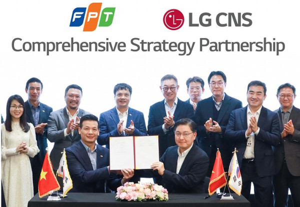 LG CNS 현신균 대표(오른쪽 다섯번째), FPT그룹 응우옌 반 코아(왼쪽 네번째) CEO 등 관계자가 지켜보는 가운데 통신/유통/서비스사업부장 박상균 전무와 FPT그룹 부 아잉 뚜 CTO가 MOU를 체결하고 있다.